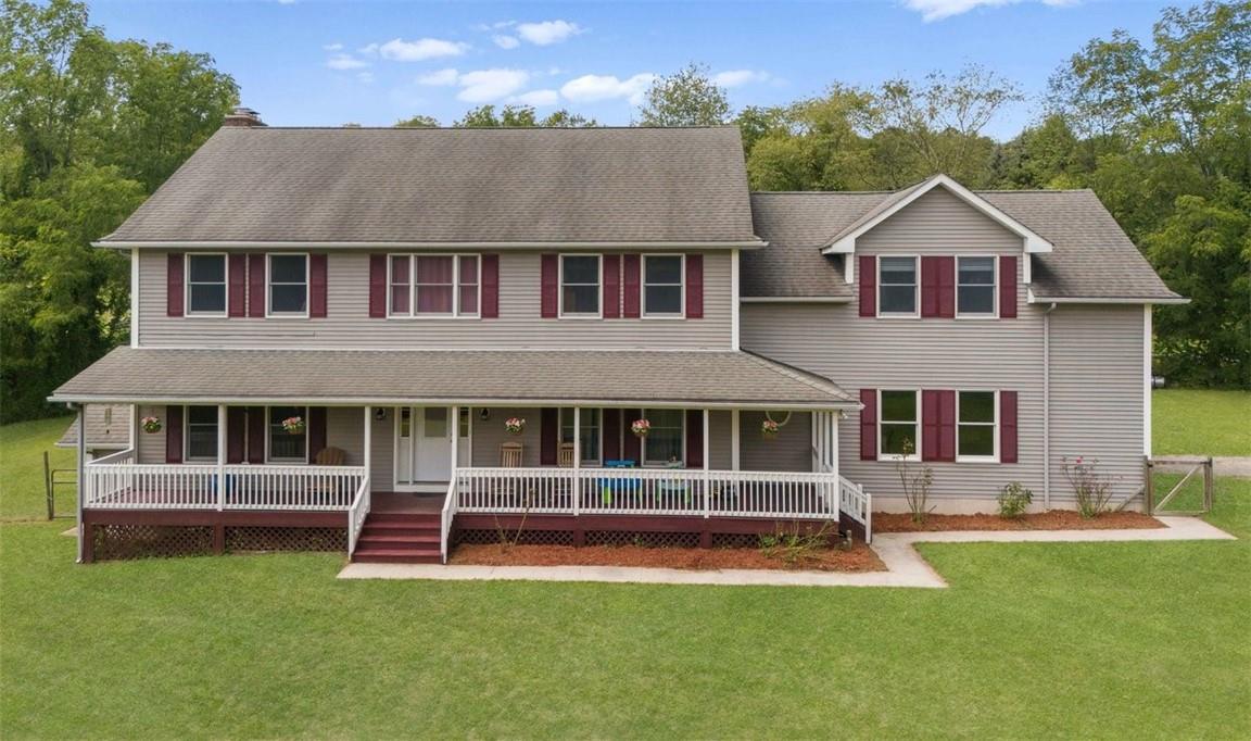 a view of a house with a swimming pool and a yard