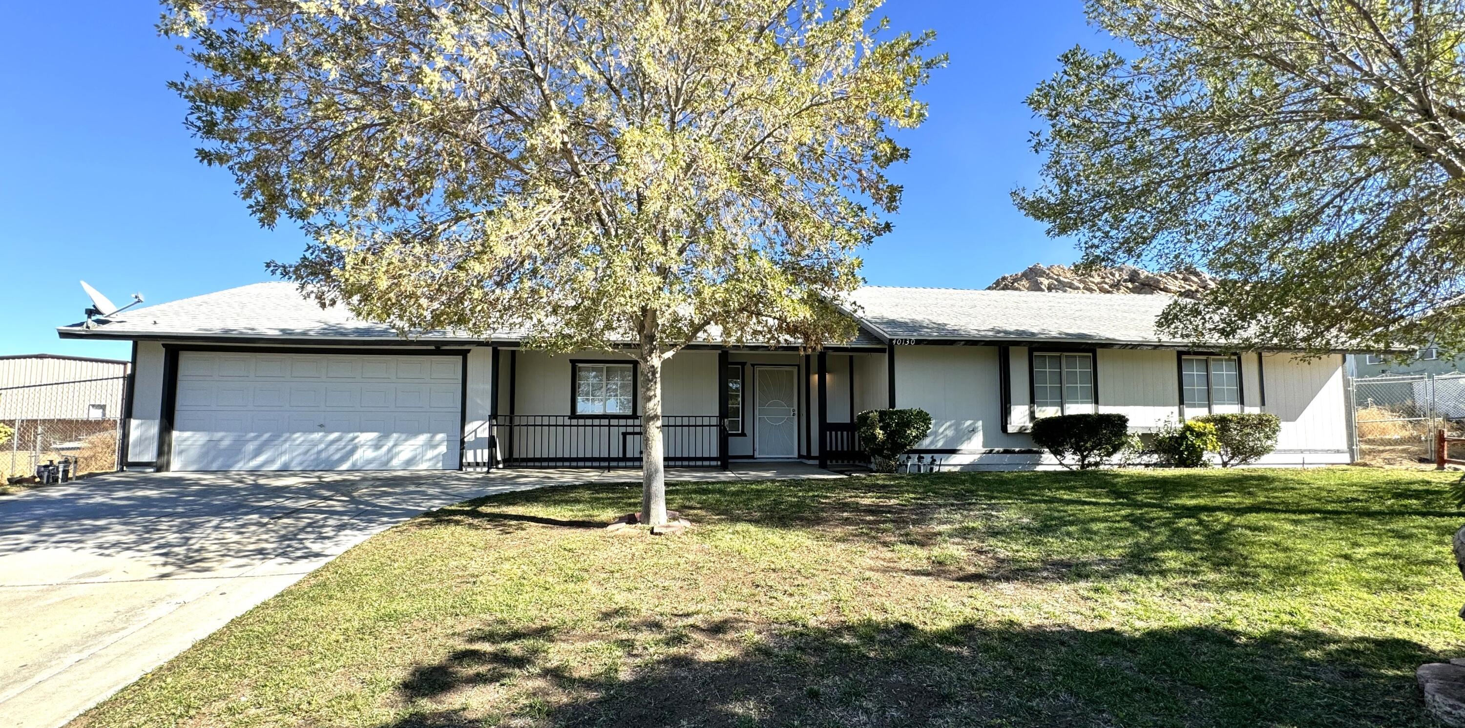 a front view of a house with a yard garage and chair