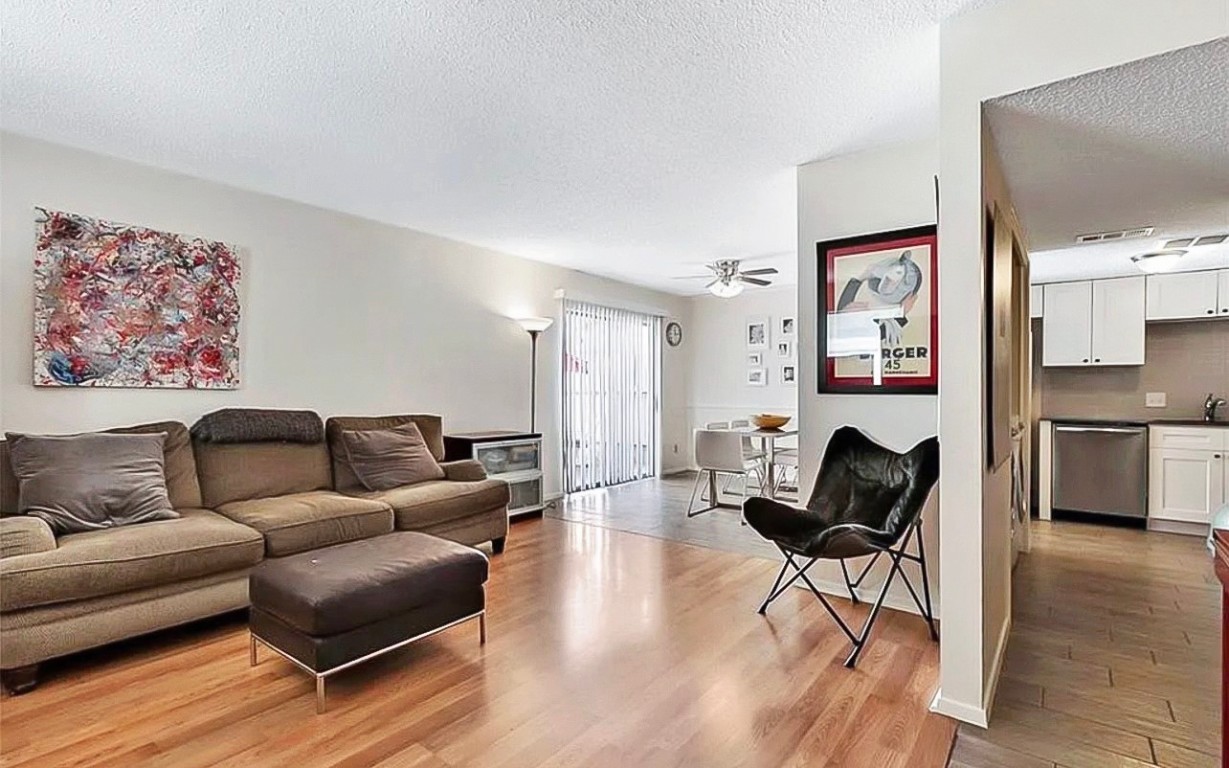 a living room with furniture and a view of kitchen