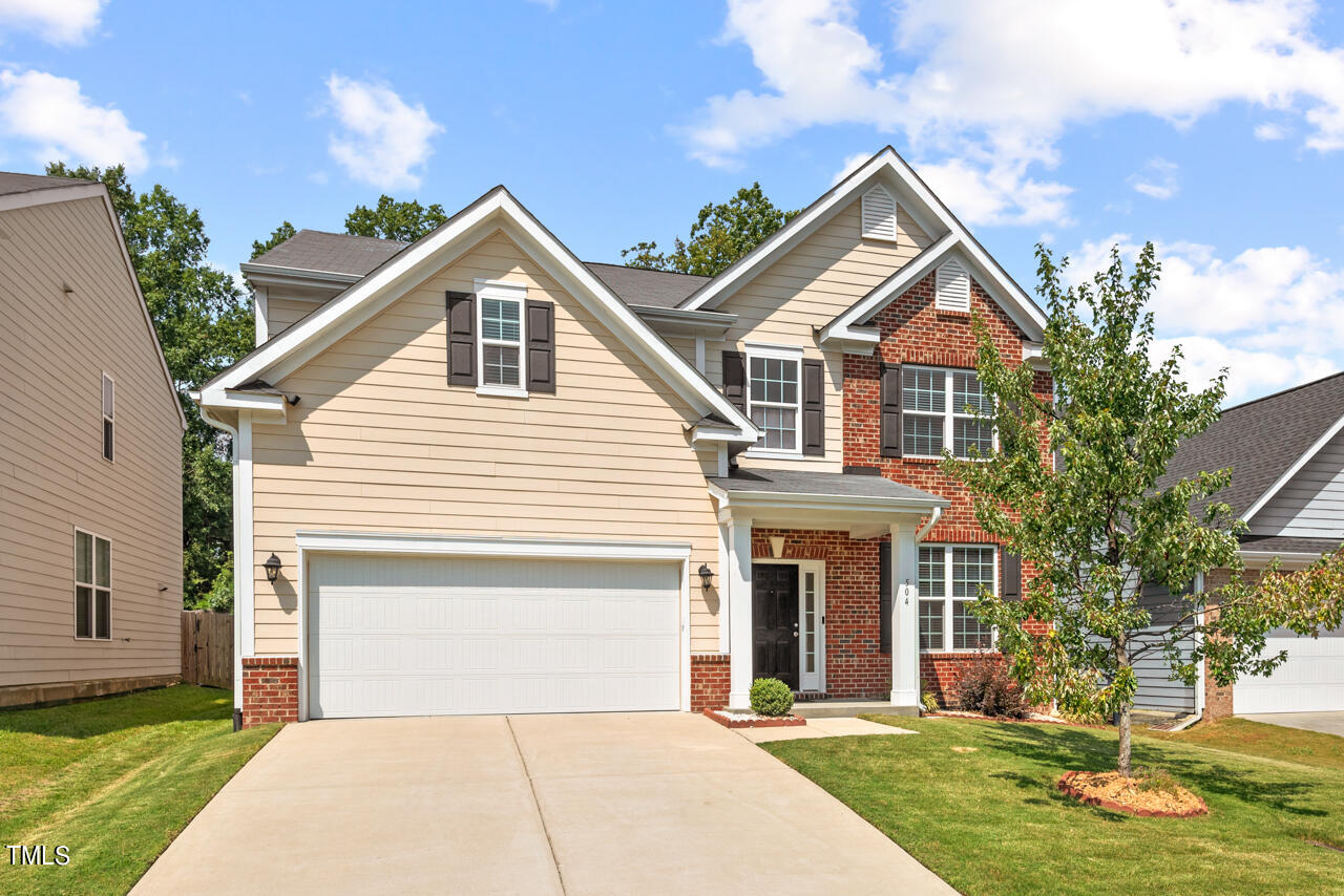 a front view of a house with a yard and garage