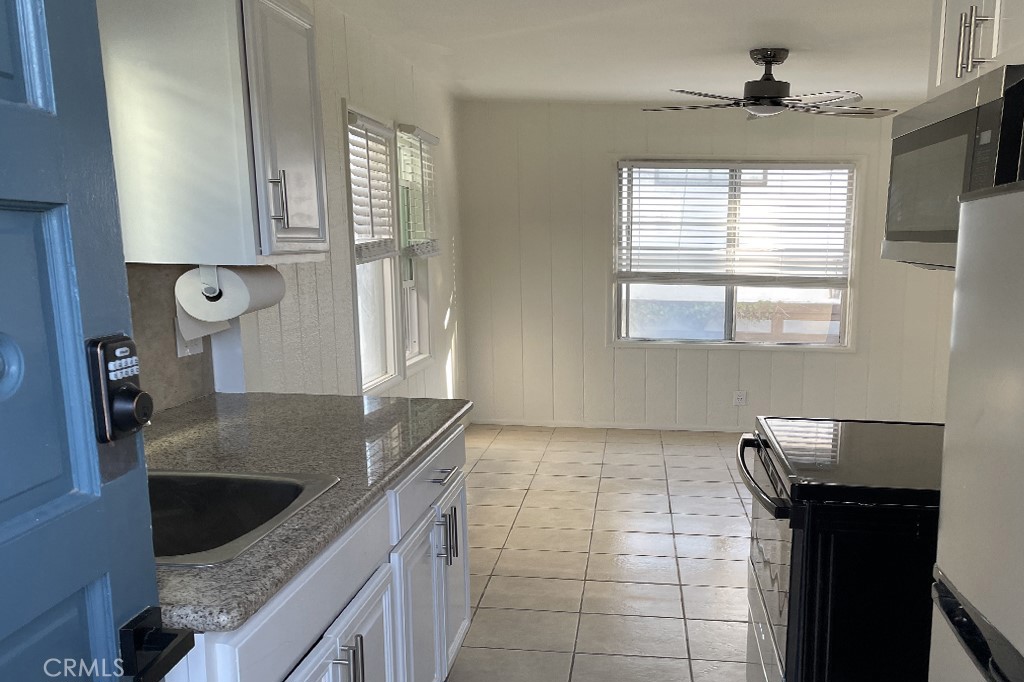 a kitchen with granite countertop a sink a counter top space and windows