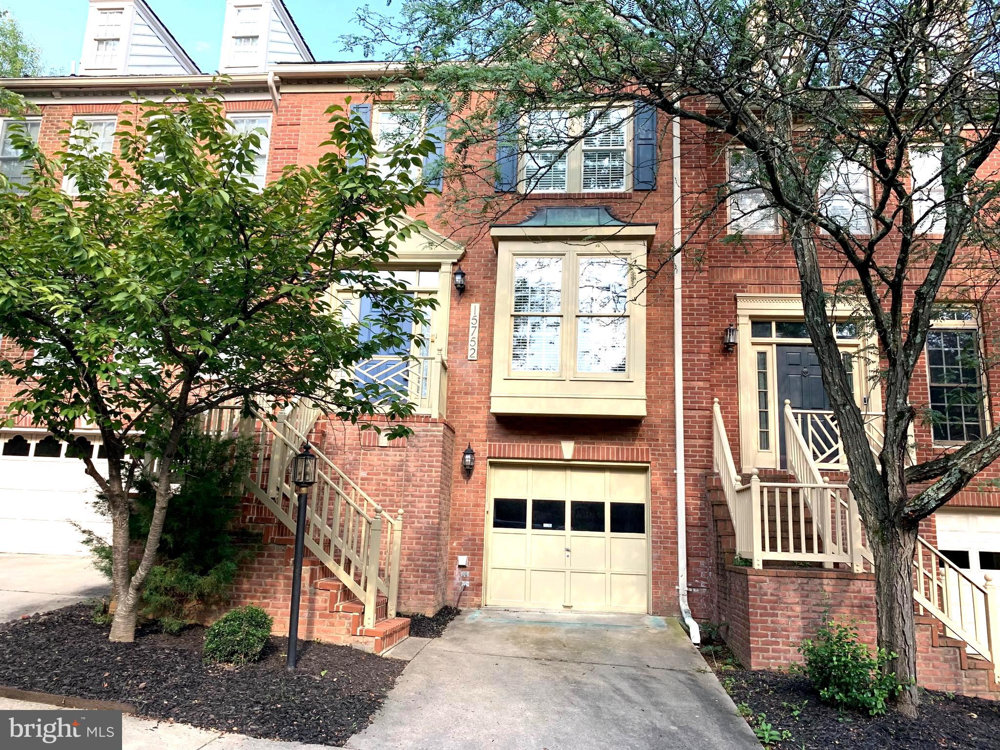 a front view of a house with a tree