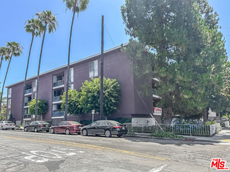 a couple of cars parked in front of brick building