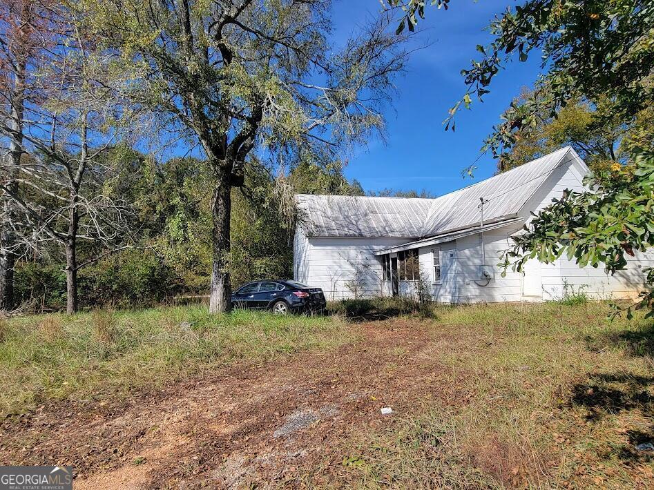 a view of a house with a yard and tree