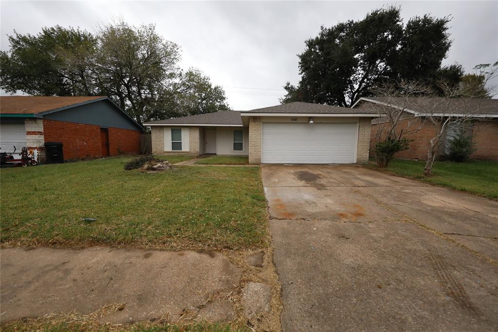 a view of a house with a yard and large tree