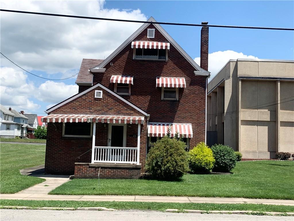 a view of a house with a small yard and potted plants