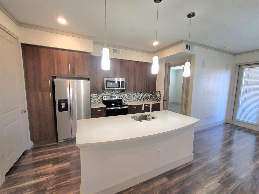 a large kitchen with stainless steel appliances a refrigerator and microwave