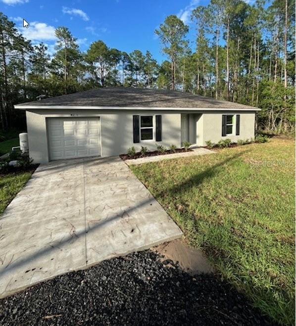 a front view of house with yard and trees in the background