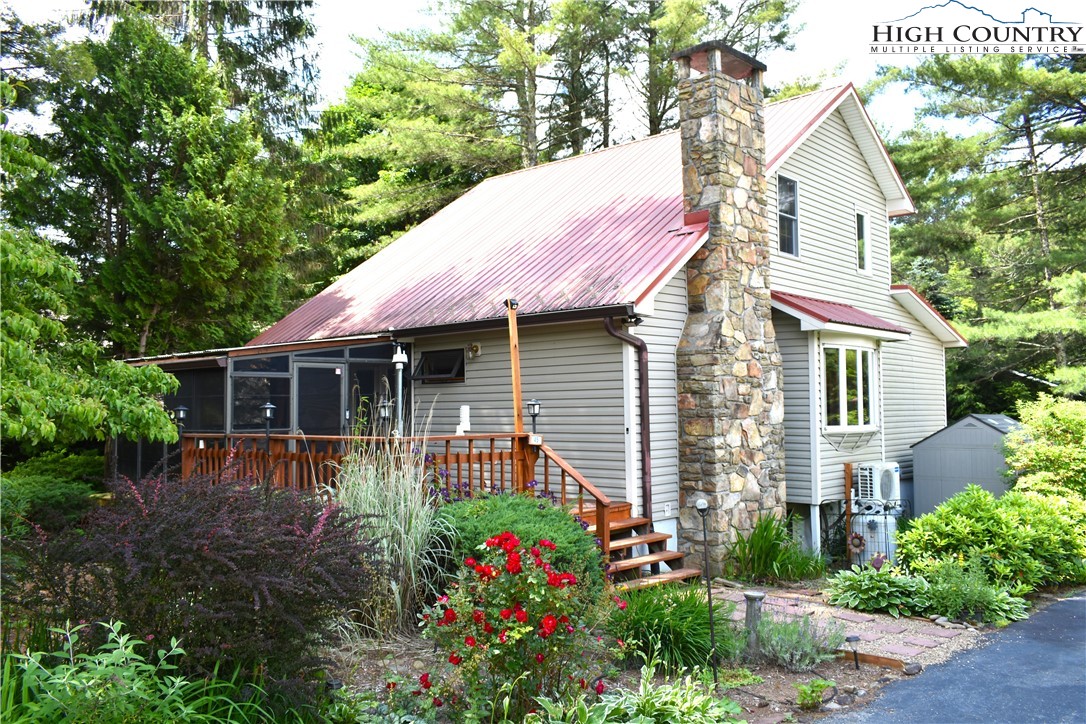 a front view of a house with a porch and a garden