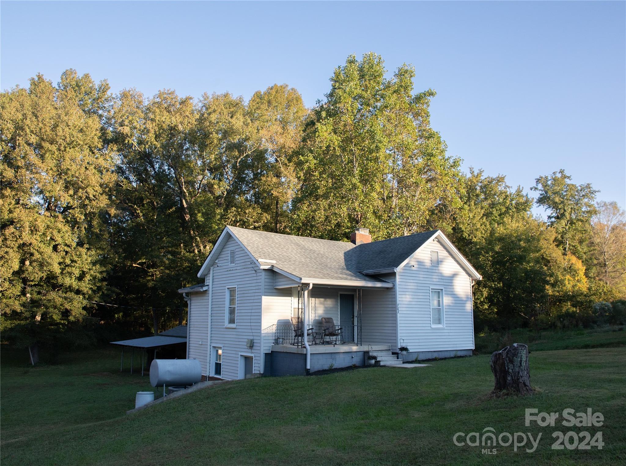 a front view of a house with a yard and trees