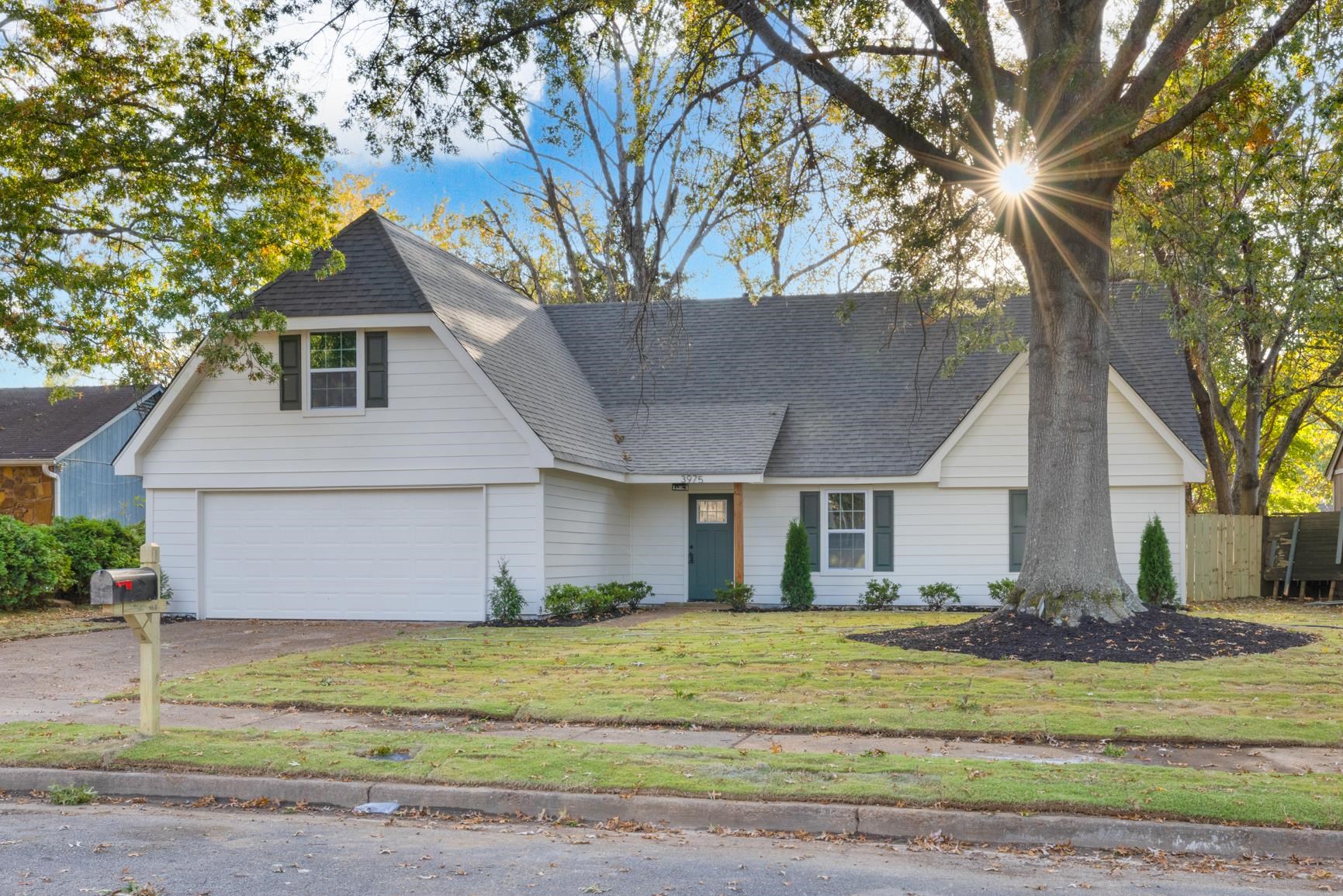 View of front of house with a garage and a front lawn