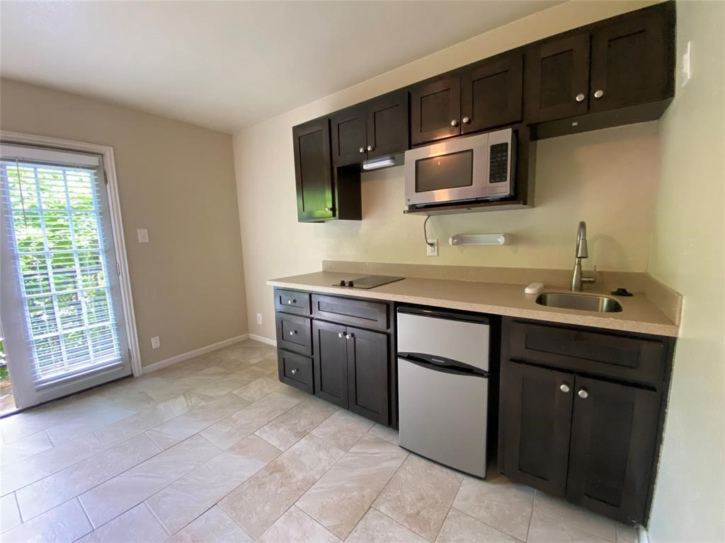 a kitchen with stainless steel appliances granite countertop a sink and a microwave