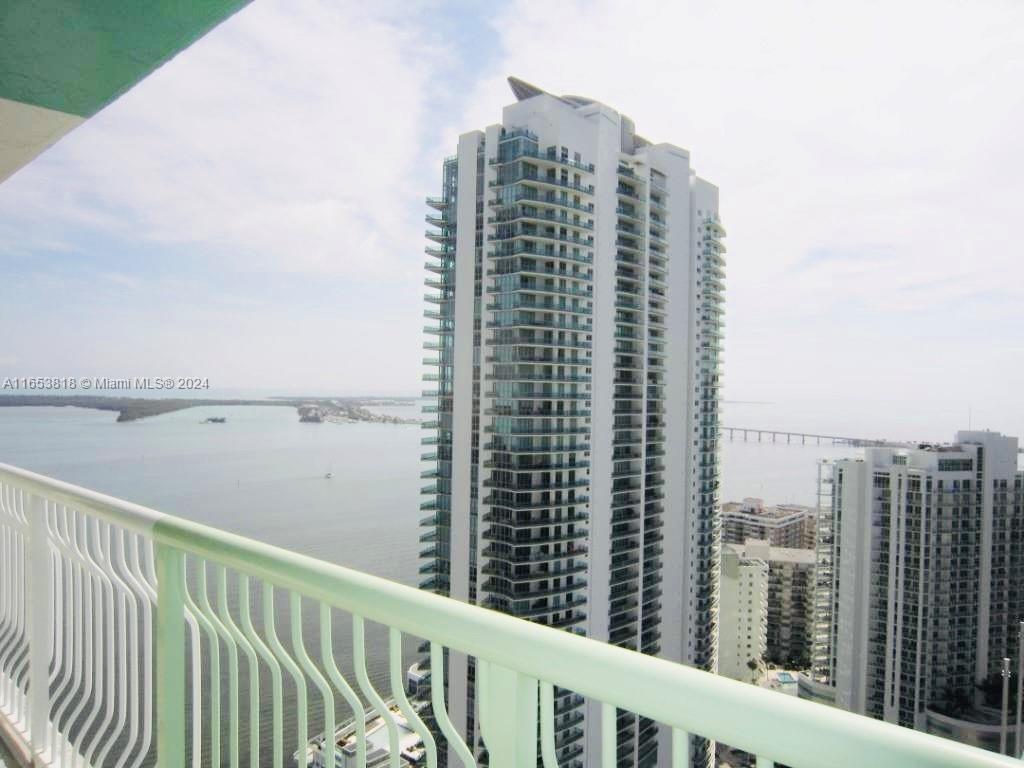 a view of a tall building next to a lake