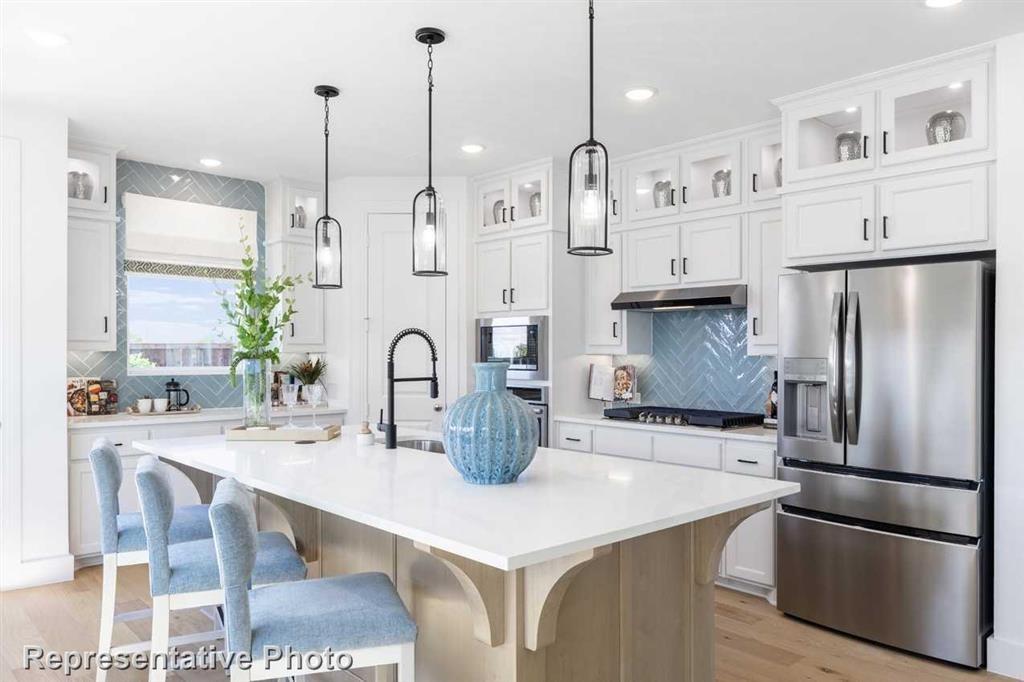 a kitchen with refrigerator and white cabinets