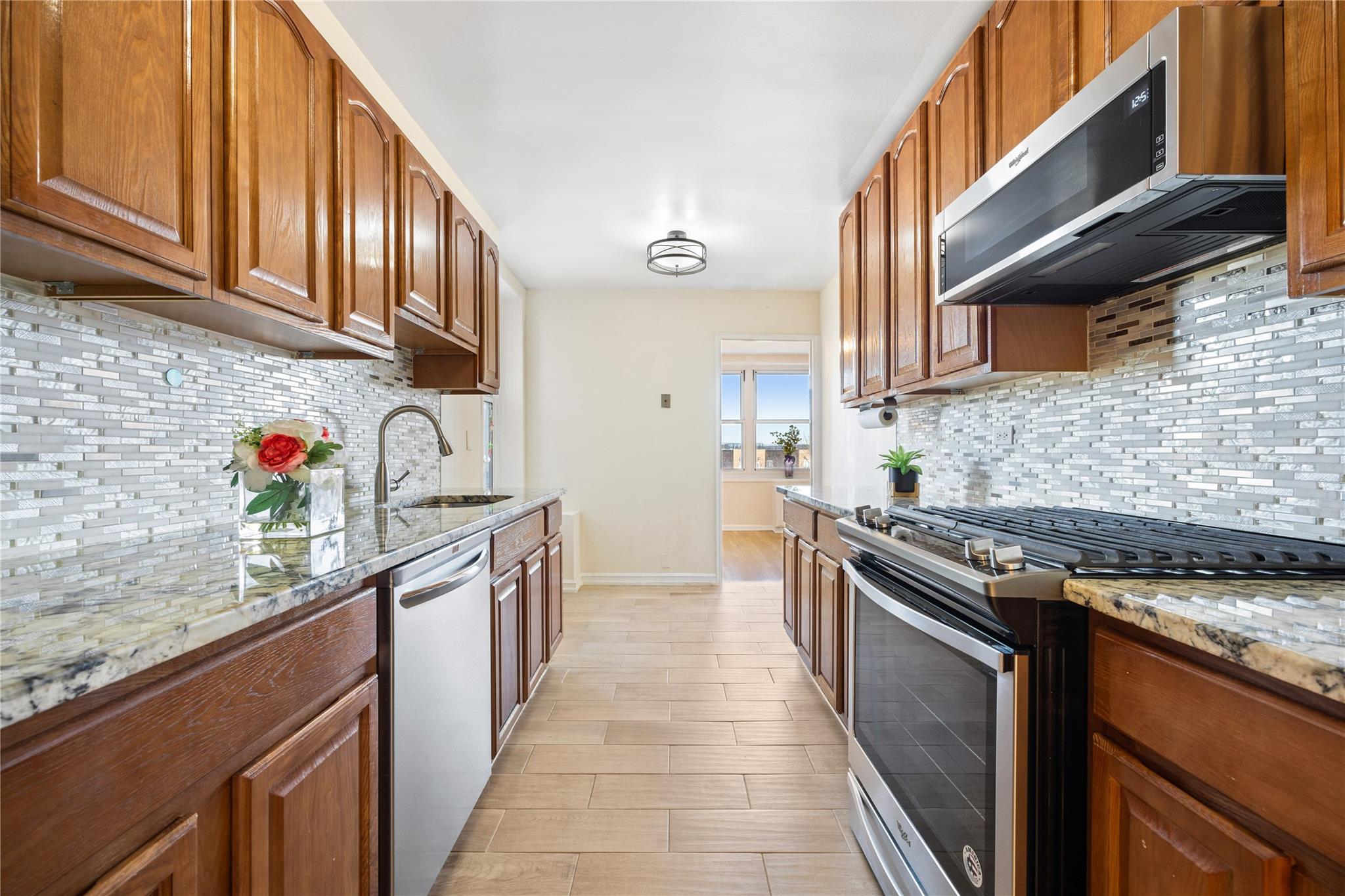 Kitchen with sink, light stone countertops, stainless steel appliances, and tasteful backsplash