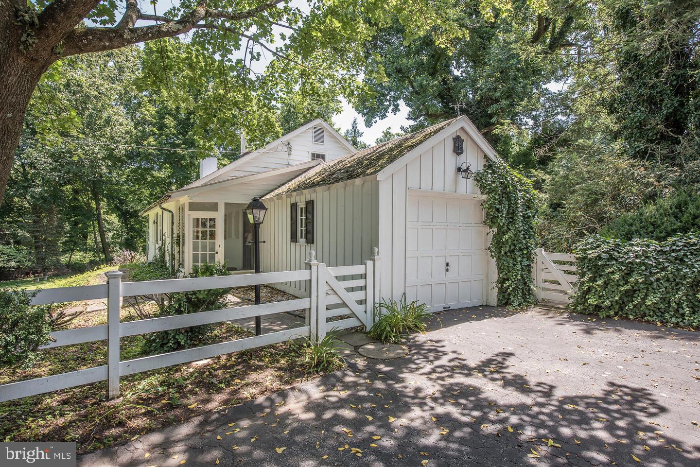 a backyard of a house with wooden fence and large trees