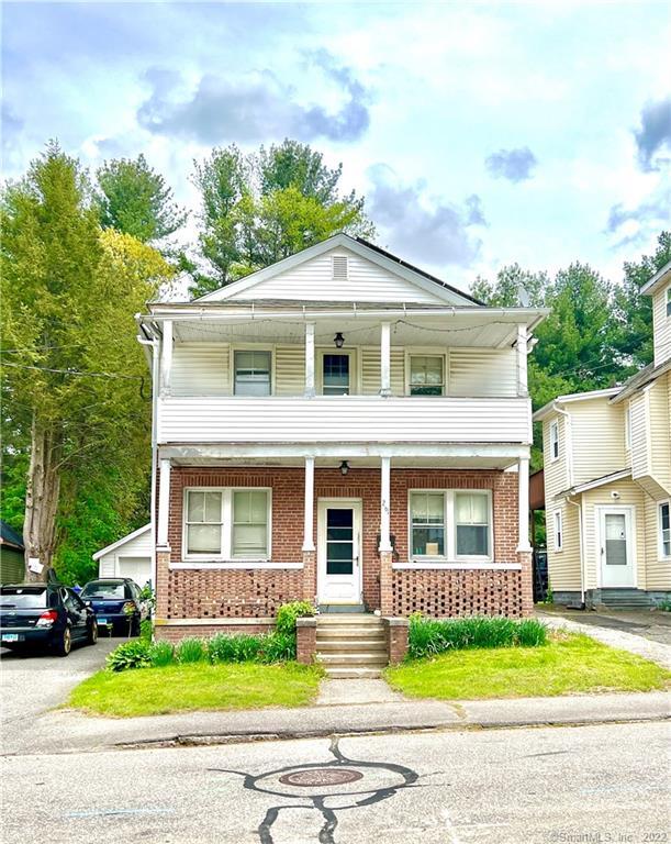 a front view of a house with a yard and potted plants