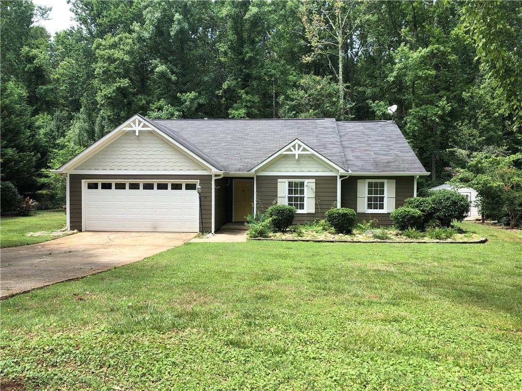 a front view of a house with a yard and trees