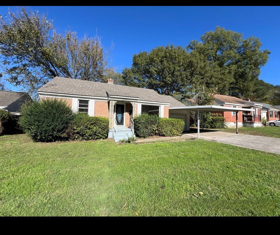 Single story home featuring a carport and a front yard