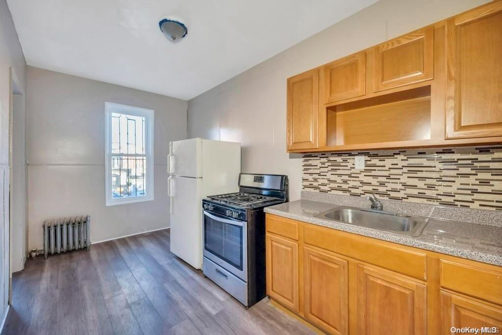 a kitchen with granite countertop wooden floors and stainless steel appliances