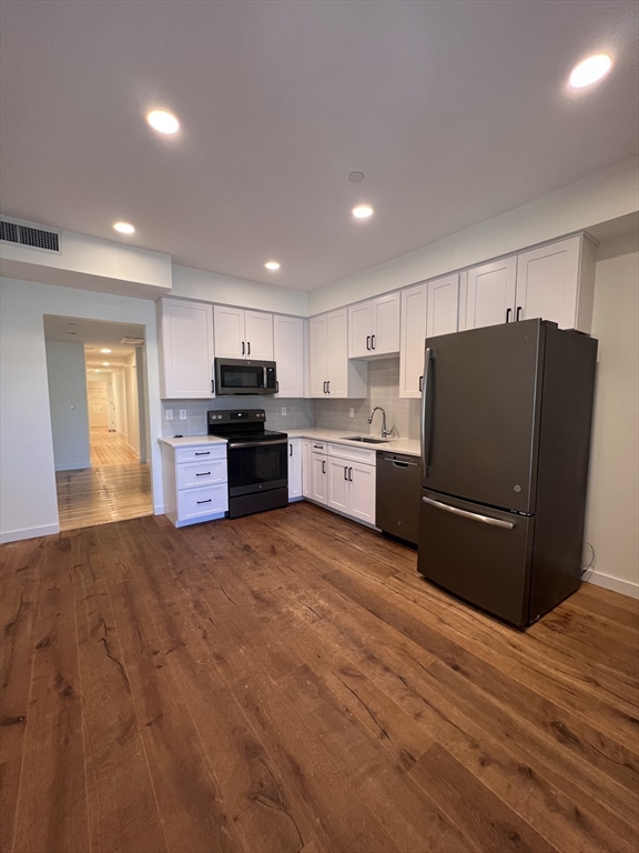 a kitchen with stainless steel appliances granite countertop a refrigerator and a stove top oven