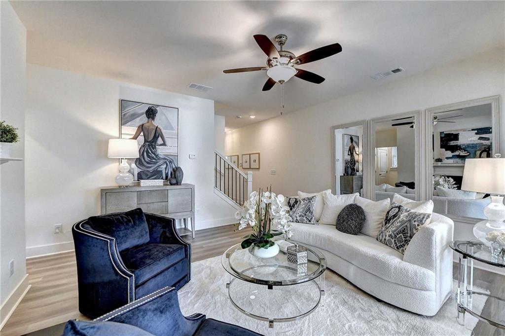 a living room with furniture and a wooden floor