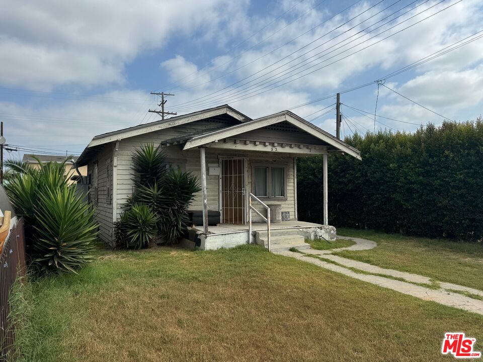 a view of house with backyard and outdoor seating