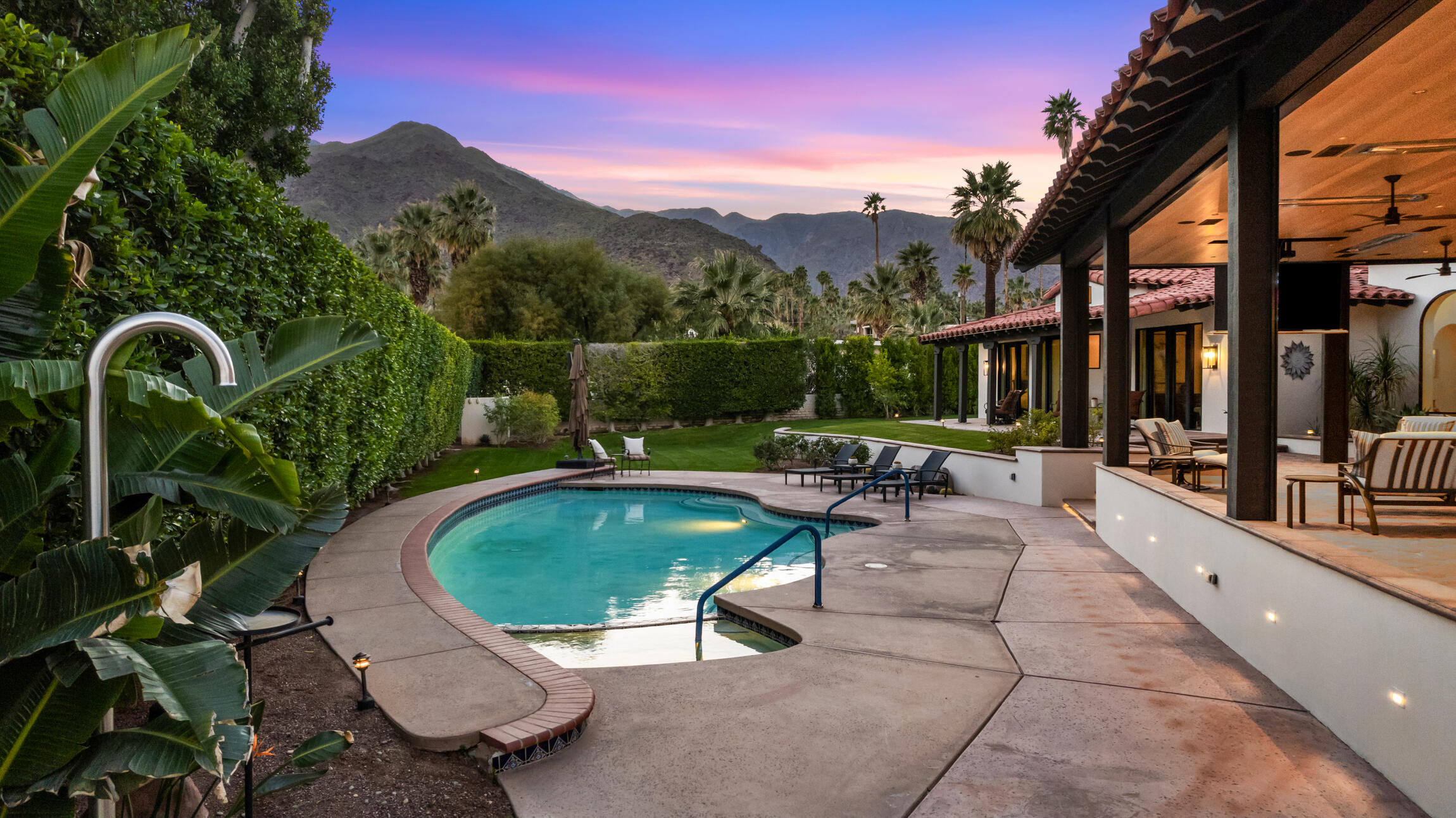 a view of a swimming pool with a patio and a yard