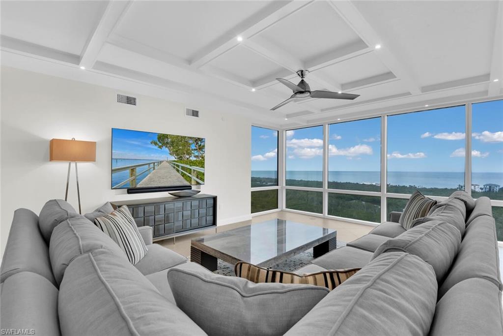 a living room with furniture and a floor to ceiling window