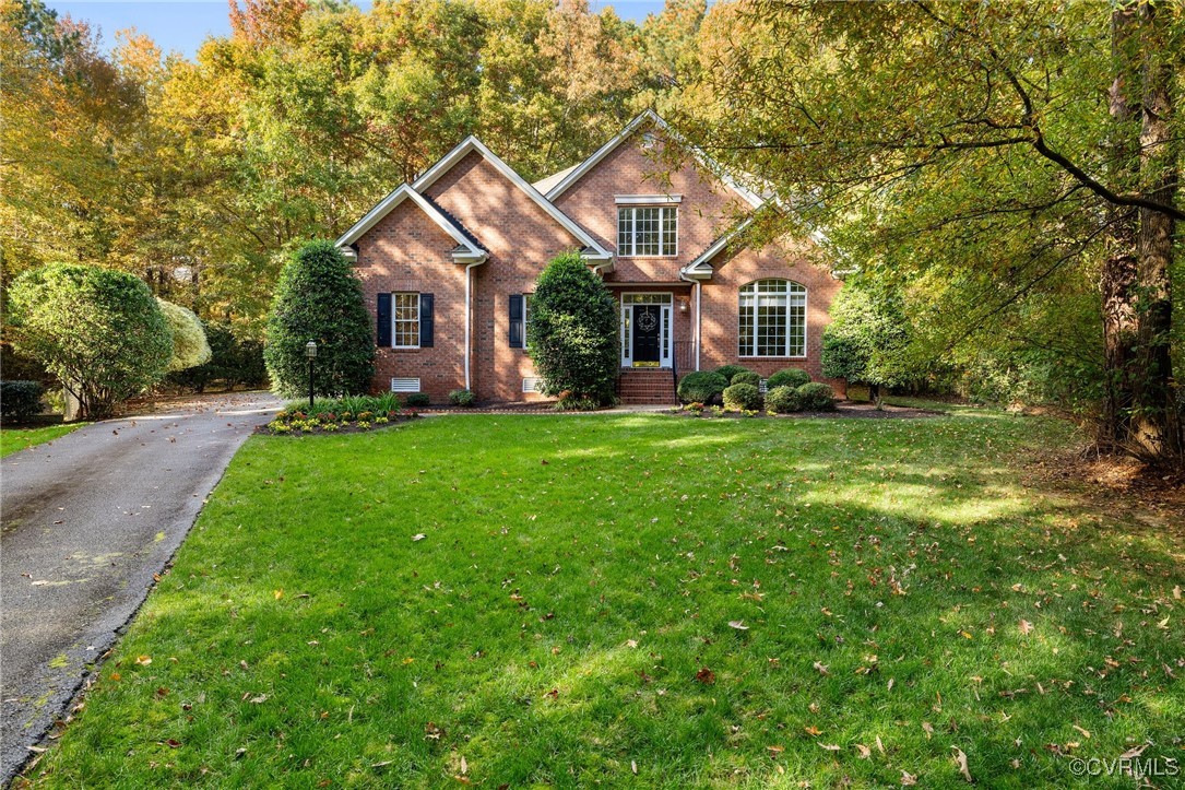 a front view of a house with a yard and trees