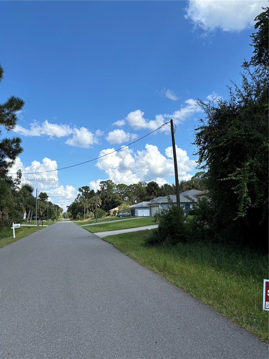 a view of a street with a big yard