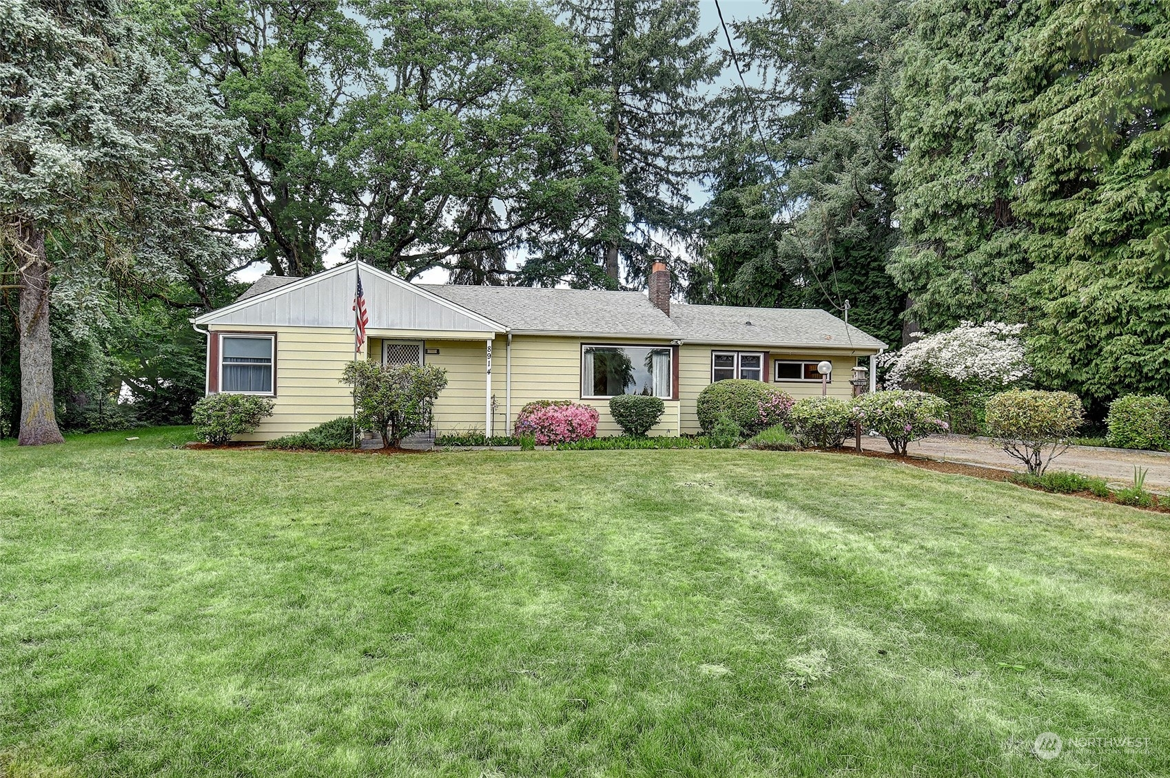 a front view of a house with a yard and trees