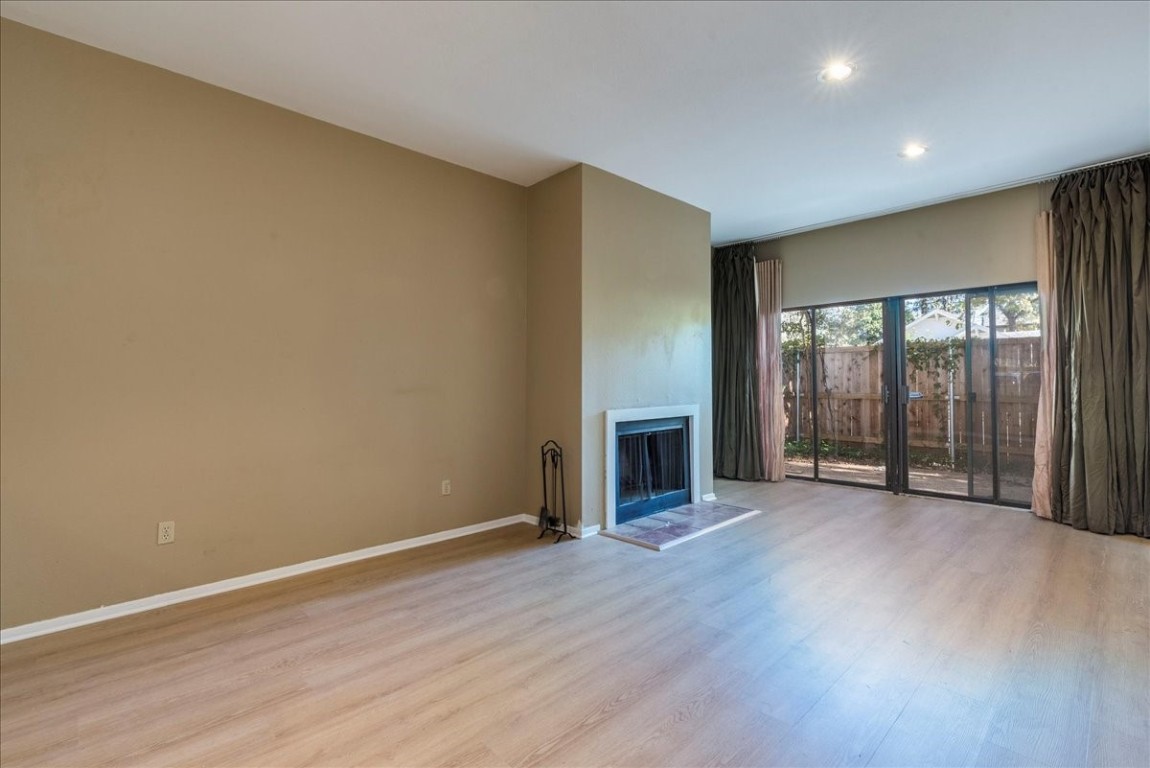 an empty room with wooden floor and fireplace