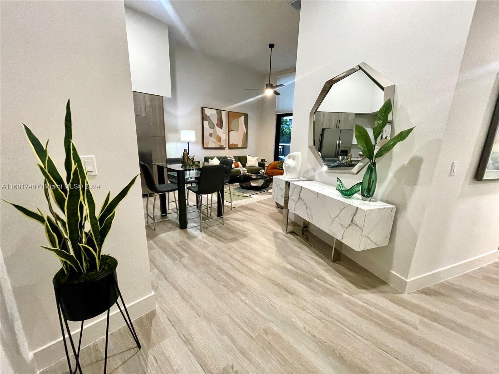 a living room with furniture mirror and a potted plant