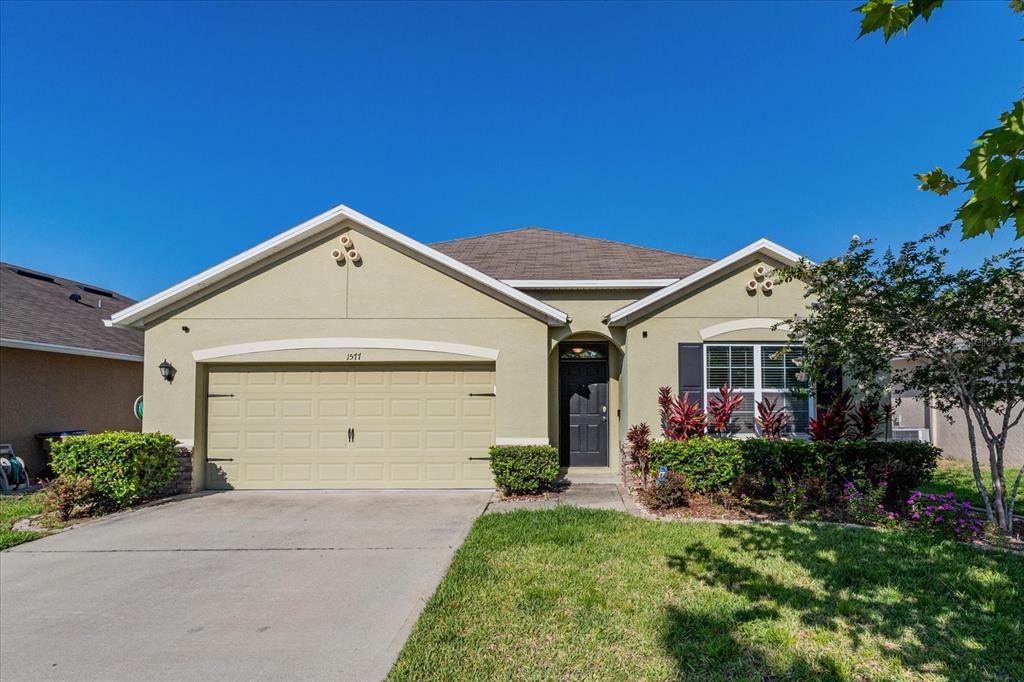 a front view of a house with a yard and garage