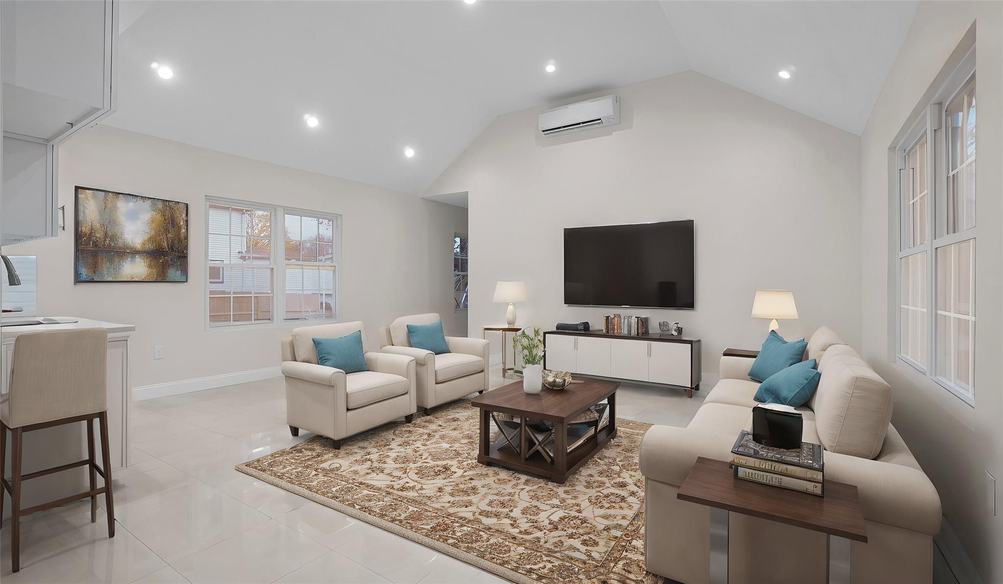 Tiled living room featuring sink, vaulted ceiling, and a wall unit AC