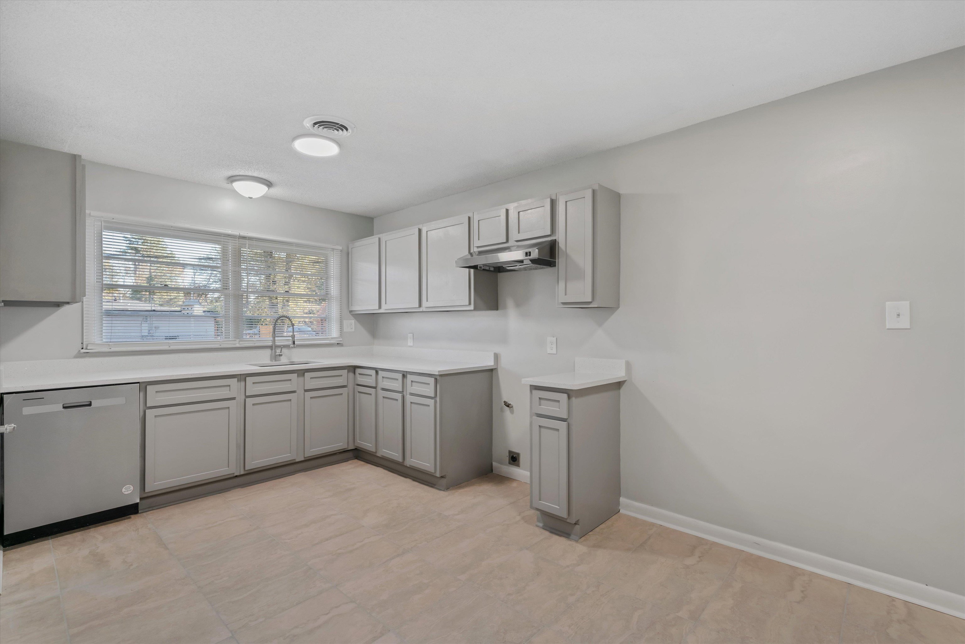 a kitchen with cabinets appliances a sink and a window