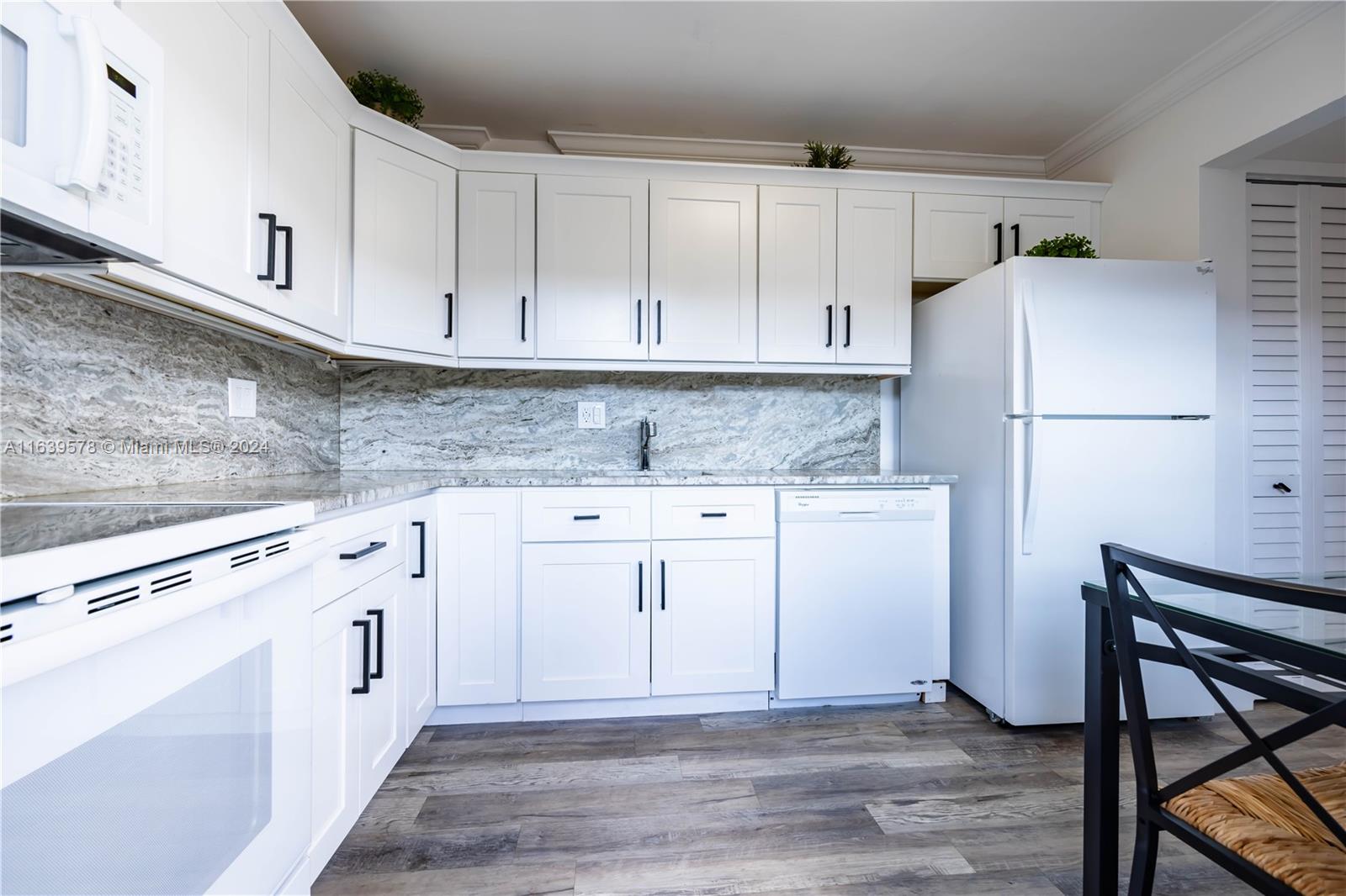 a kitchen with white cabinets and white appliances