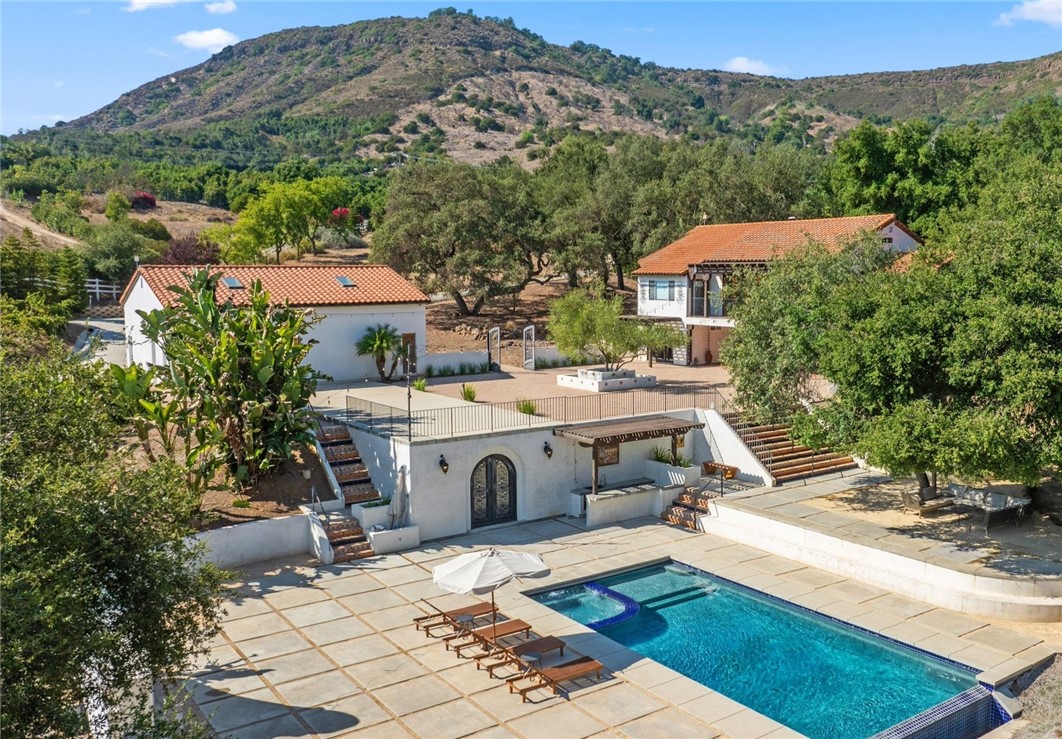 an aerial view of a house with yard swimming pool and mountain view