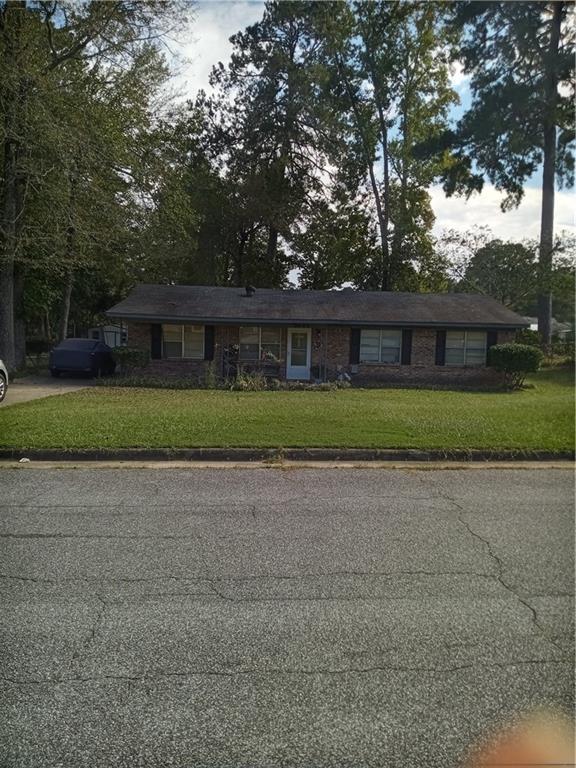 front view of house with a yard and a trees