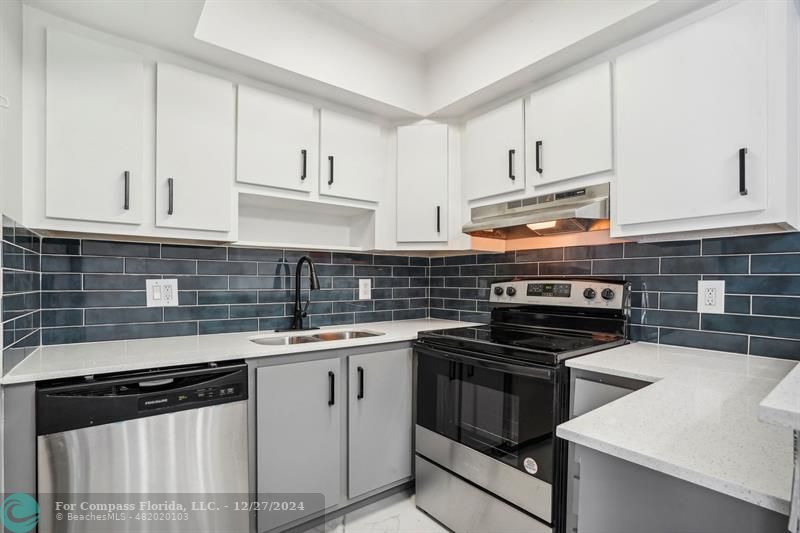 a kitchen with cabinets stainless steel appliances and sink