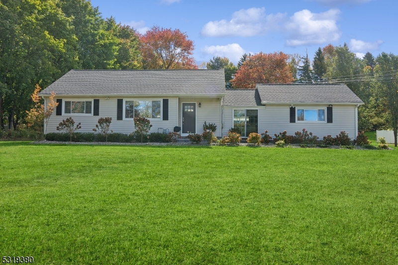 a front view of a house with garden and trees