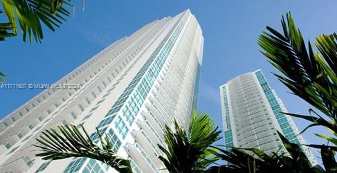 a view of a tall building with a palm tree in the background