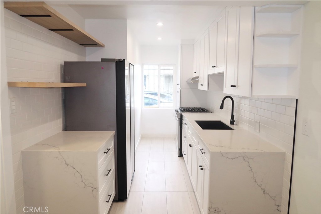 a kitchen with a sink a refrigerator and cabinets