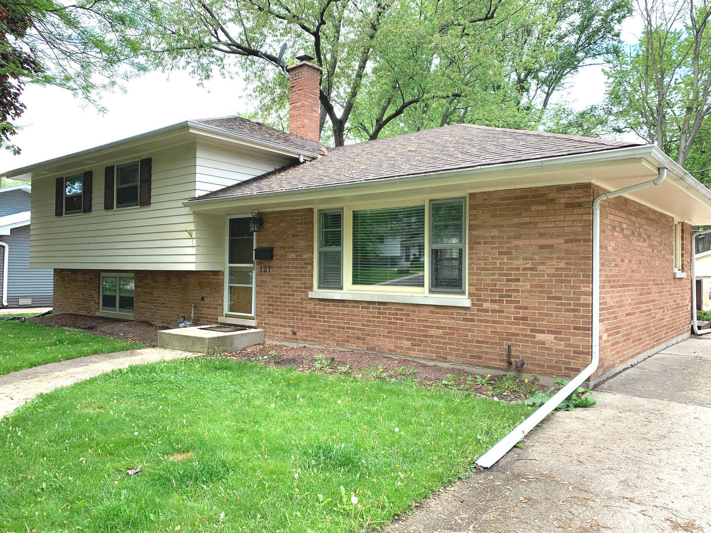 a front view of a house with a garden and yard