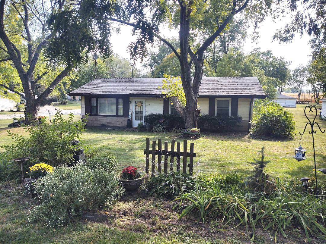 a view of a house with backyard and sitting area