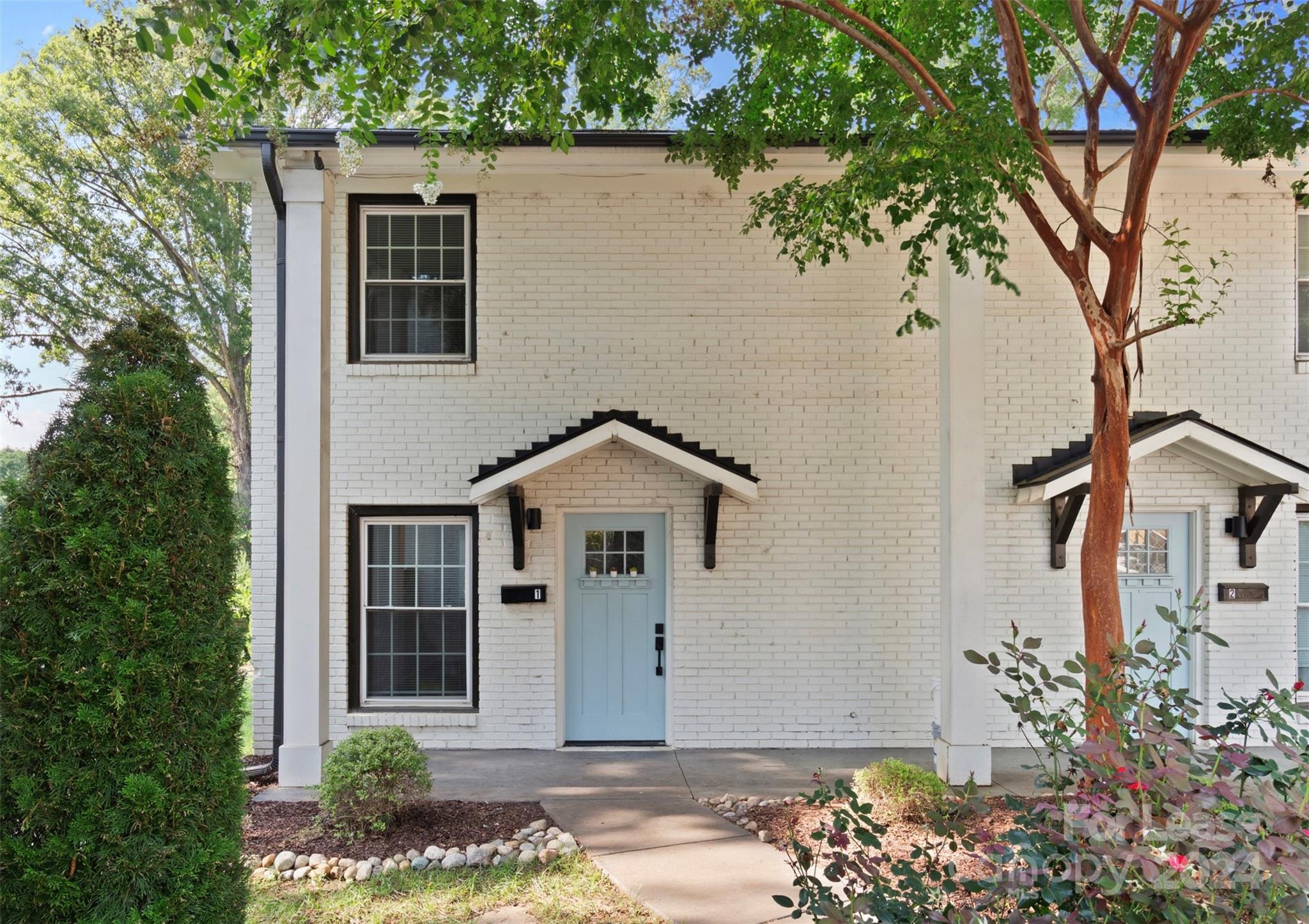 a front view of a house with a garden