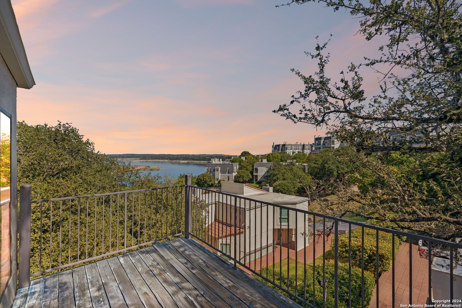 a view of a balcony with wooden floor and fence