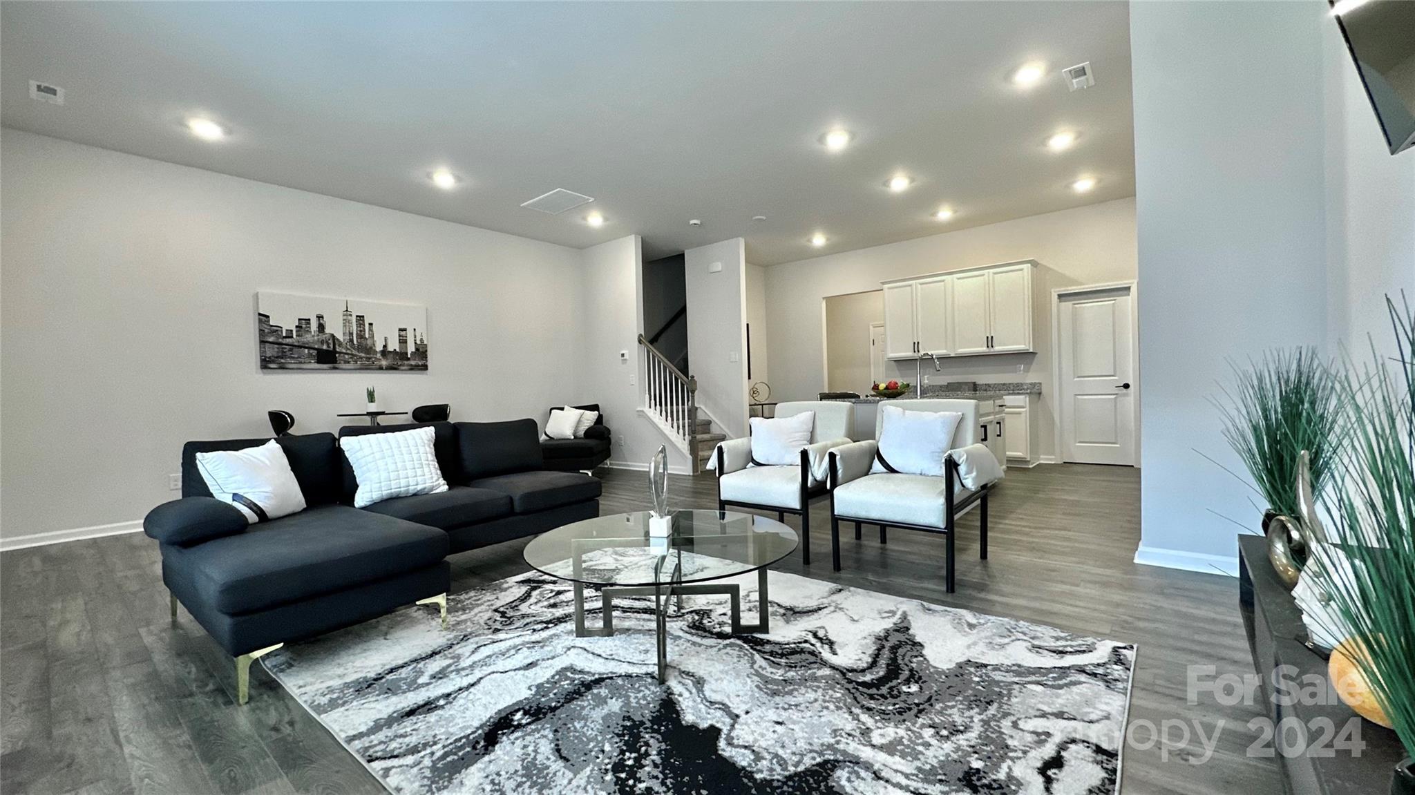 a living room with furniture and wooden floor