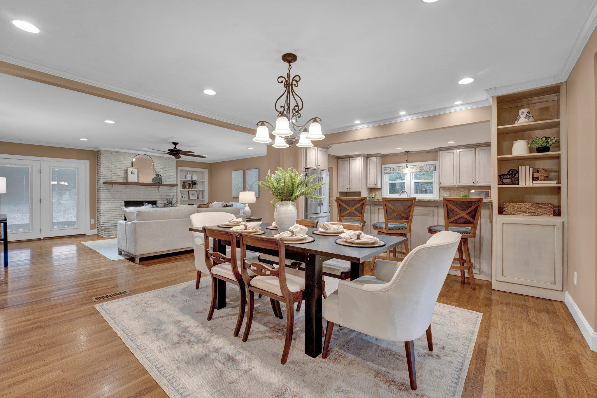 Dining space with a fireplace, light hardwood / wood-style floors, and ornamental molding